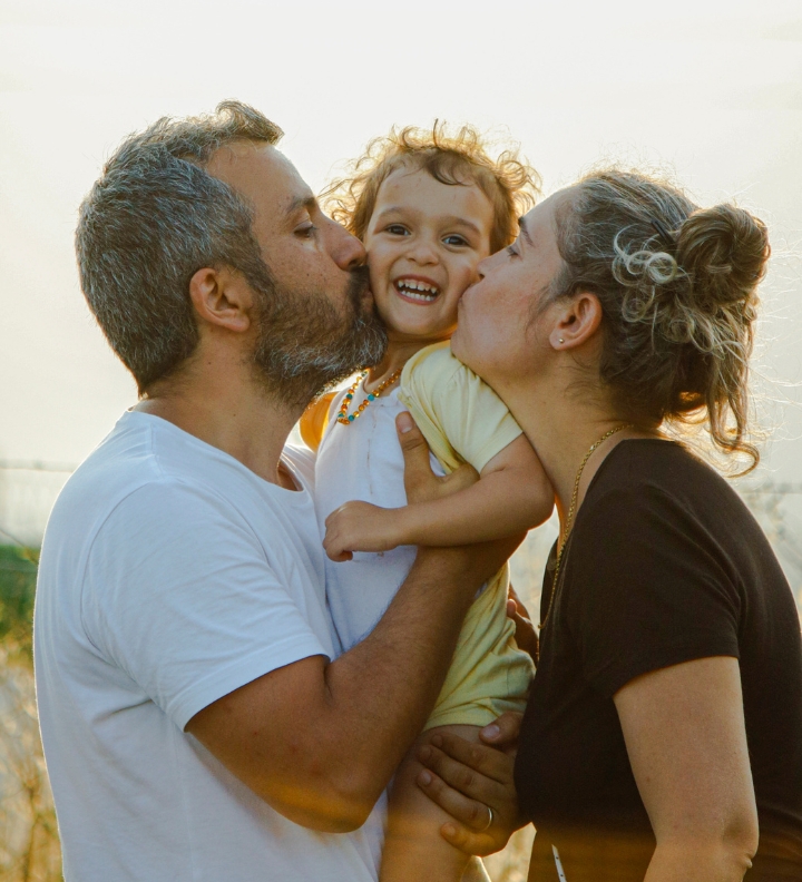 Mother and father kissing baby Mother and father kissing baby